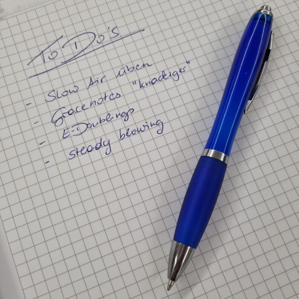 To Do Liste auf karriertem Papier mit blauem Kugelschreiber