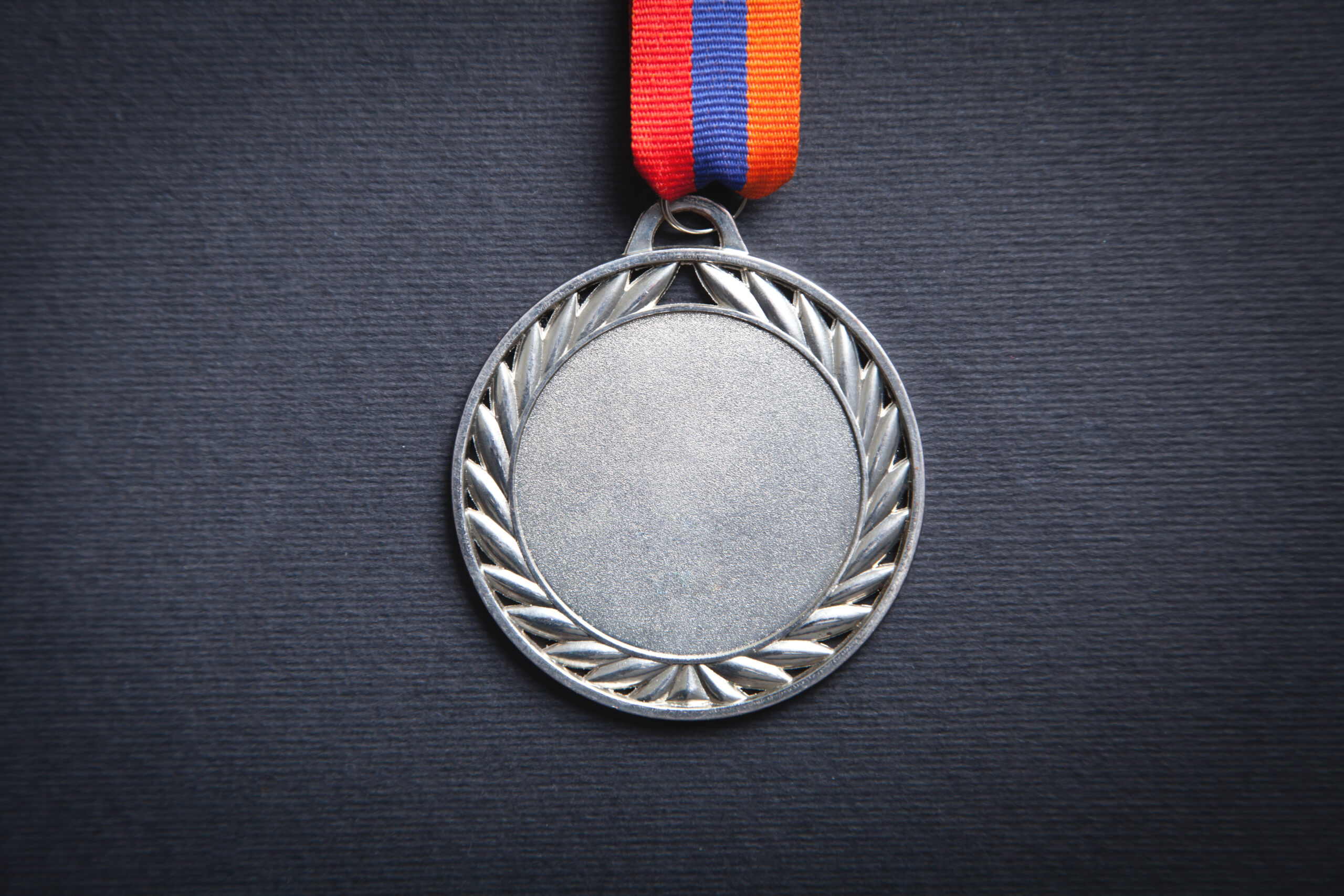 silber Medaille mit rot blauem Band auf dunklem Hintergrund